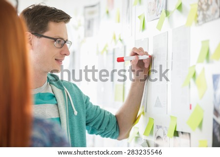 Creative businessman writing notes on paper in office