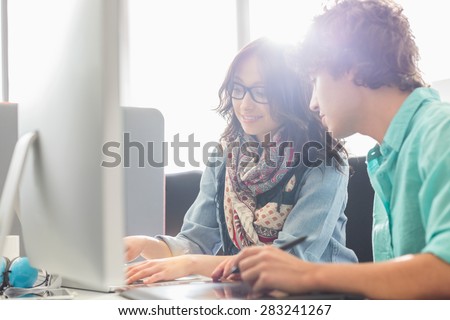 Creative business colleagues using desktop computer in office