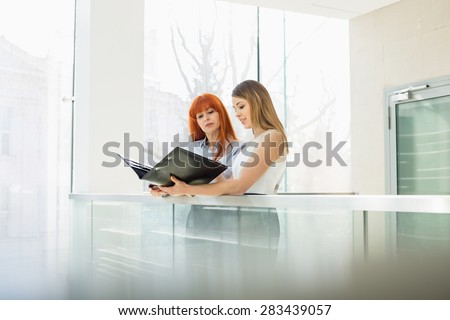 Businesswomen discussing over file folder in office
