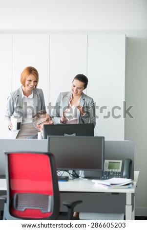 Business people having lunch while using computer in office