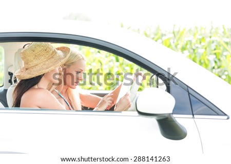 Female friends using digital tablet in car