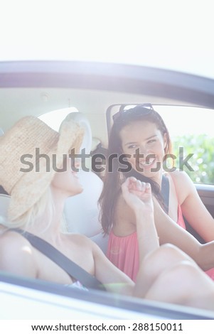 Cheerful female friends enjoying road trip in car