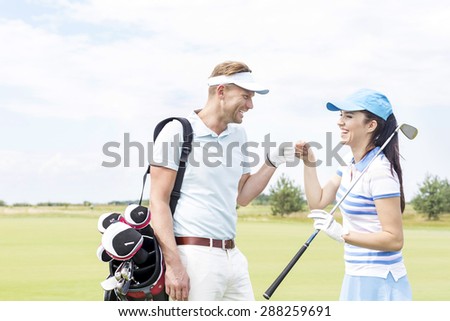 Cheerful friends giving high-five at golf course