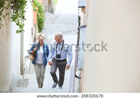 High angle view of middle-aged couple holding hands while climbing steps outdoors