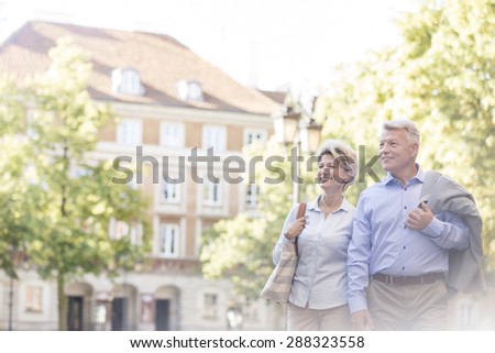 Happy middle-aged couple walking in city