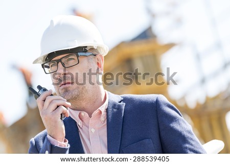 Male supervisor using walkie-talkie at construction site