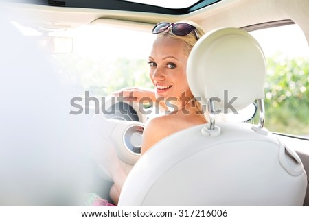 Rear view portrait of happy woman driving car