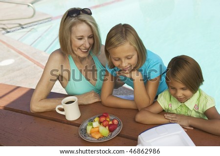Girls and Grandmother Watching TV at Pool