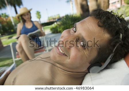 Man Lying on Lawn Chair Listening to Music