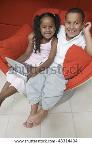 Brother and Sister in Chair with DVD Player