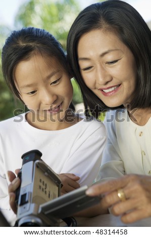 Mother and Daughter Looking at Video Camera Screen