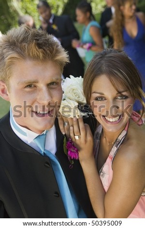 Well-dressed teenage couple standing outside school dance, elevated view