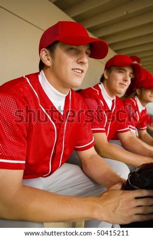 Baseball team-mates sitting in dugout