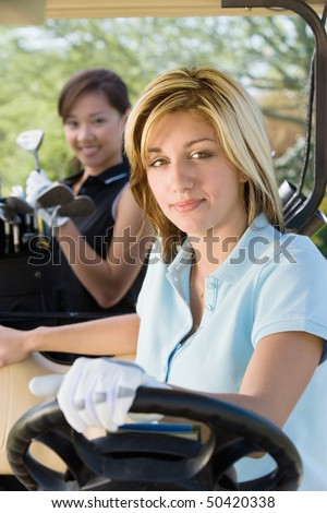 Two female golfers sitting in golf cart