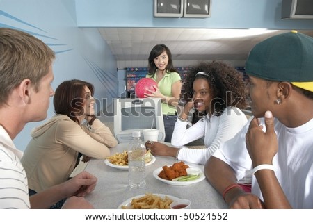 Group of friends eating at bowling alley