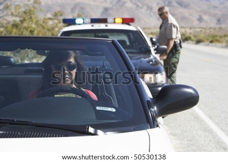 Women sitting in car being pulled over by police officer