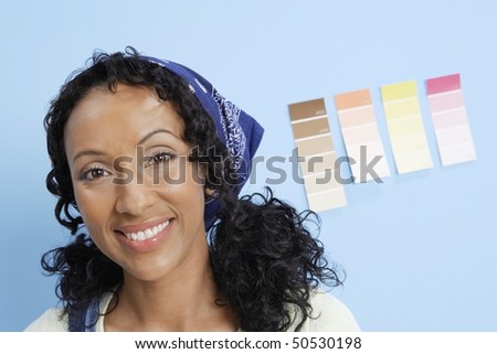 Woman in front of paint colour samples on interior wall, close-up, portrait