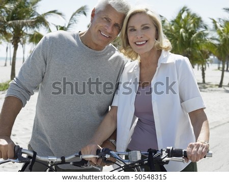 Senior couple on bicycles on tropical beach