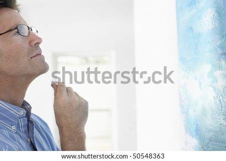 Man observing painting in art gallery