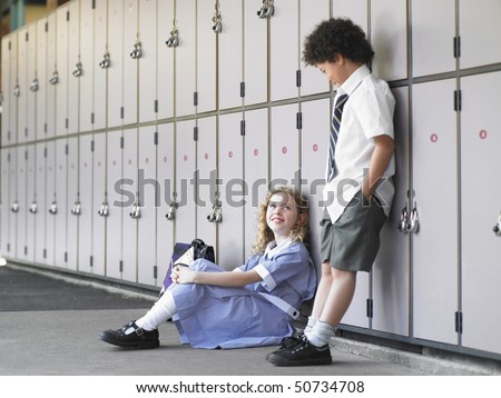 Two elementary school students waiting by school lockers