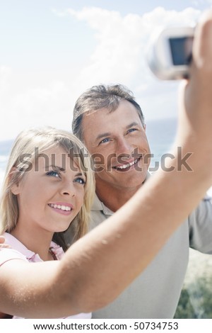 stock photo Teenage Girl Taking Picture of Herself and Father