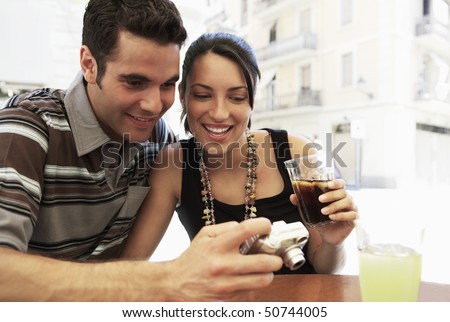 Young couple at cafe looking at camera together, portrait