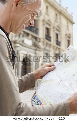Tourist on Granada street Reading Map, side view