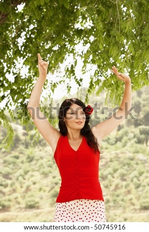 Woman flamenco dancing outdoors, front view.