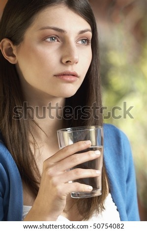 Young woman drinking glass of water, portrait