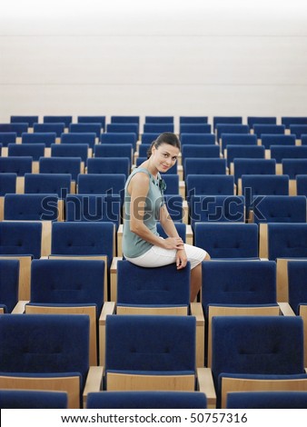 Businessman sitting alone on chair in Auditorium, portrait