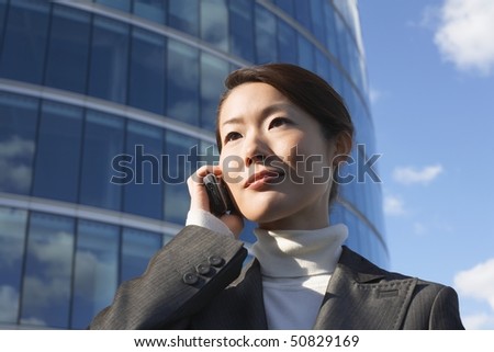 Businesswoman standing outside office building, Using Cell Phone, close-up
