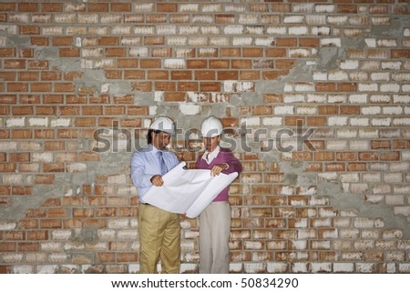 Construction manager and architect examining plans