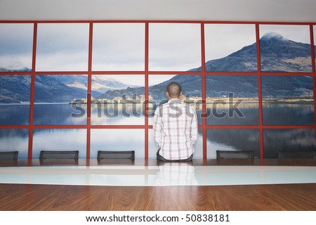 Man Staring at Wall Photo in Conference Room, back view
