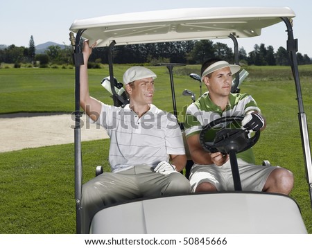 Two young male golfers sitting in cart