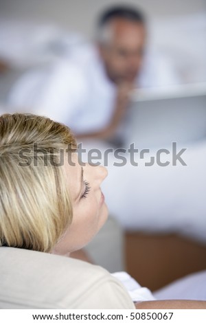 Woman relaxing sitting in armchair in bedroom, elevated view