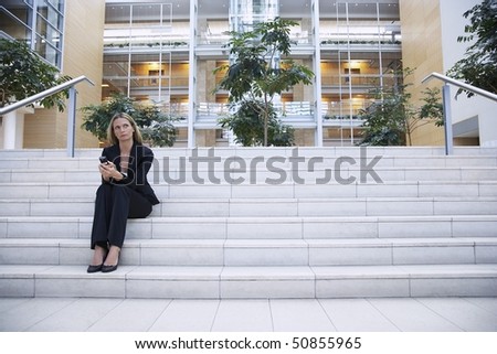 Businesswoman sitting on steps outside office