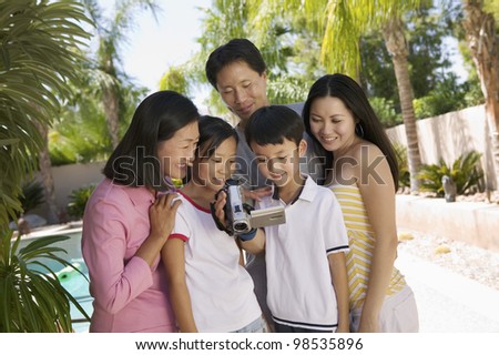 Family Looking at Video Camera Screen