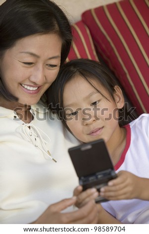 Mother and Daughter Playing Handheld Video Game
