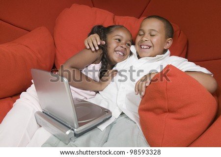 Brother and Sister in Chair with DVD Player