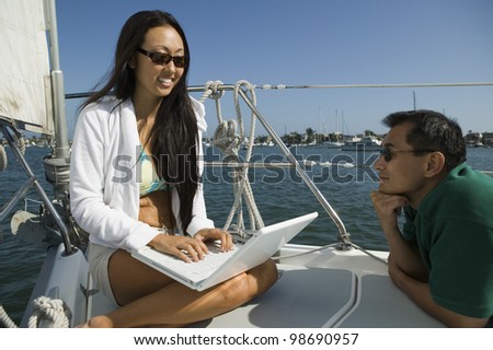 Man and Woman Using Laptop on Sailboat