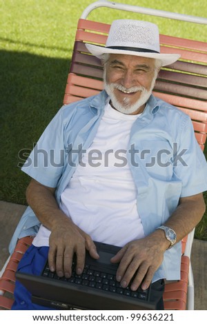 Senior Man in Lawn Chair Using Laptop
