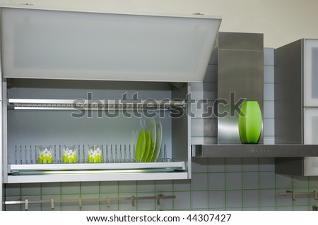 kitchen cabinet with green cups and dishes