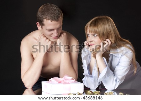 man and the woman with a gift on a black background