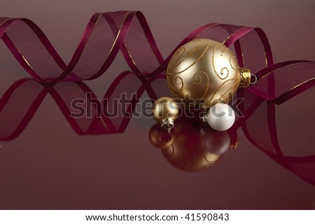 Gold and White Christmas balls reflecting on Maroon background