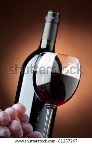 A bottle of red wine and a wine glass closeup