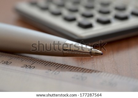 Business background with ruler, pen and calculator.