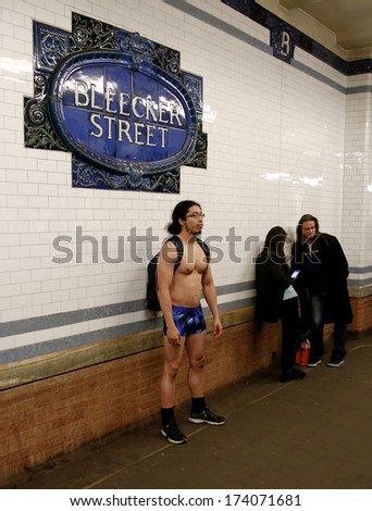 NEW YORK-JAN 12: A participant in the 13th annual international \'No Pants Subway Ride\' waits for the uptown 6 train at Bleecker Street on January 12, 2014 in New York City.