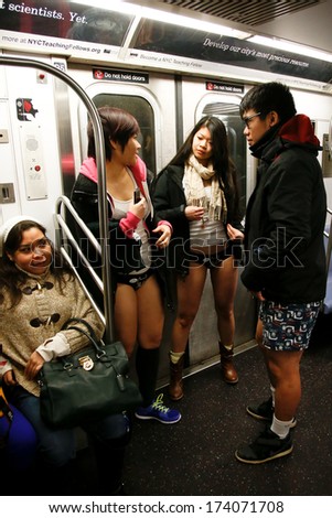 NEW YORK-JAN 12: A participant in the 13th annual international \'No Pants Subway Ride\' waits for the uptown 6 train at Bleecker Street on January 12, 2014 in New York City.