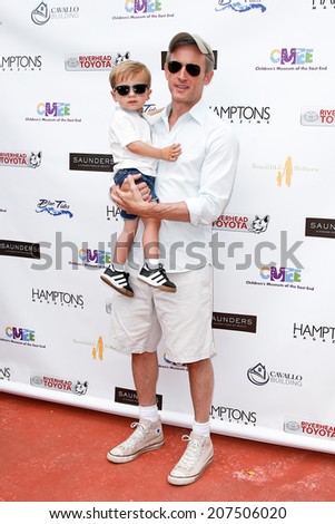 BRIDGEHAMPTON, NY-JUL 19: Actor Dan Abrams (R) and son Everett attend the 6th Annual Family Fair at the Children\'s Museum of the East End (CMEE) on July 19, 2014 in Bridgehampton, New York.