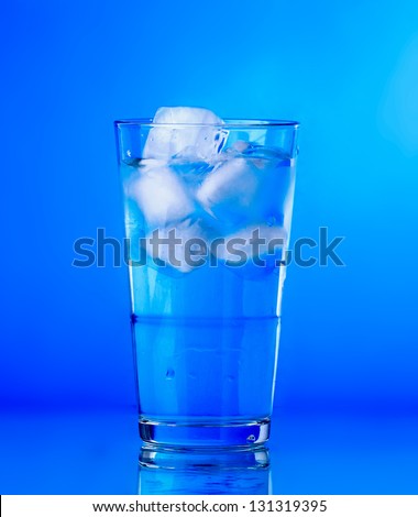 Glass of water on blue background. water with ice in glass